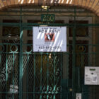 An apartment building gate displays a for rent sign.